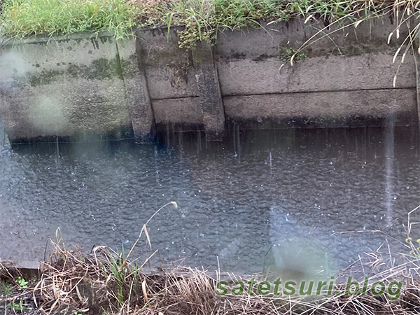 激しく雨が降る用水路